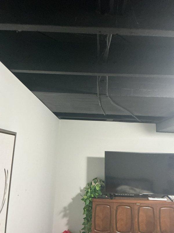 Completed electrical installation for septic system support in basement area with exposed ceiling infrastructure. Installed recessed lighting fixture and routed necessary wiring through exposed ceiling joists and ductwork to provide adequate illumination and power distribution for the finished living space below.