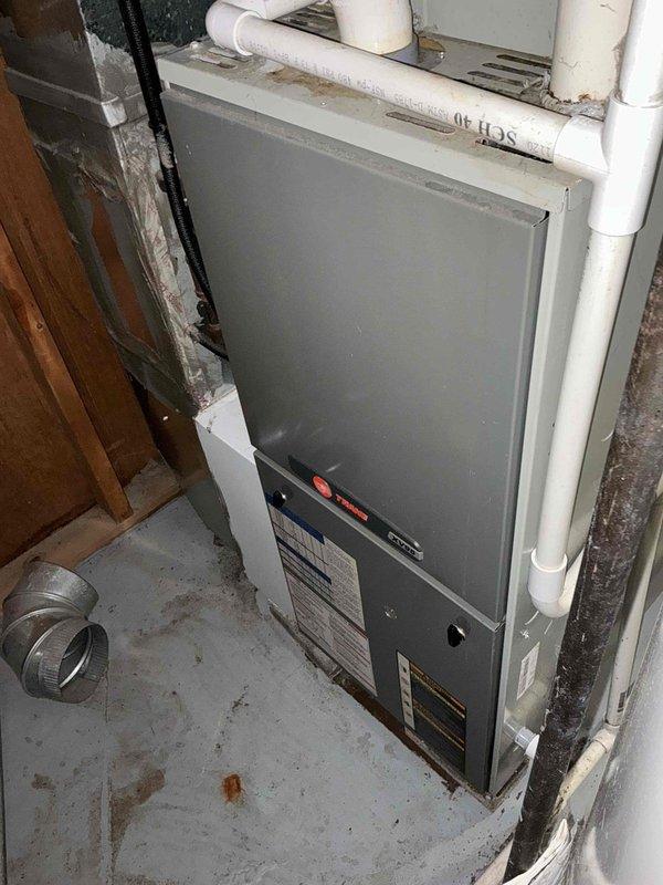 Completed HVAC estimate for full system replacement at residential property. Evaluated existing Trane furnace and air handler installation in basement utility area, assessed ductwork configuration including flexible ducting and PVC condensate lines, and provided comprehensive quote for equipment replacement. Documented current system conditions with detailed photography showing furnace positioning, venting arrangement, and surrounding infrastructure to support replacement proposal.