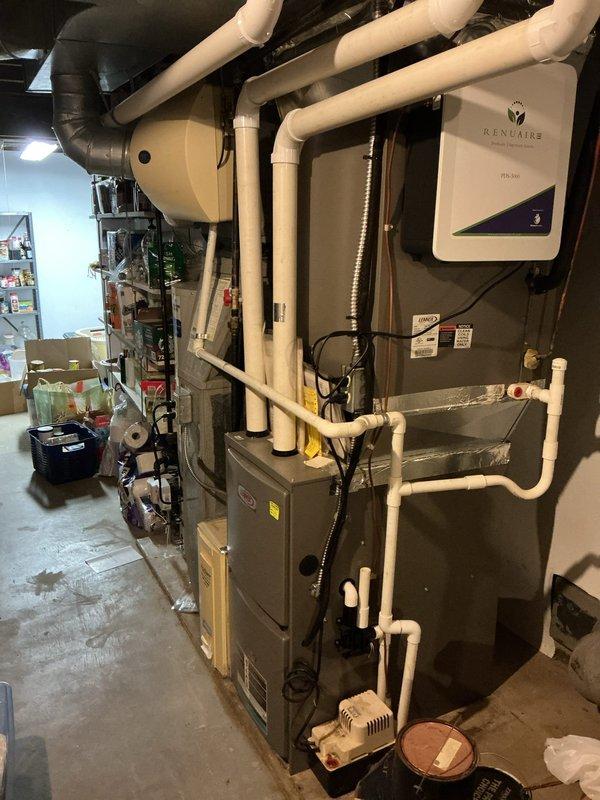 # HVAC Maintenance - Cooling

Completed routine preventive maintenance visit on a 9-year-old Lennox air conditioning system for an MVP customer. Performed comprehensive inspection of both indoor furnace unit and outdoor condensing unit, documenting equipment condition through photographic records. Outdoor unit showed adequate operational status despite vegetation encroachment around base and sides, which was noted for customer awareness regarding airflow and accessibility considerations.

Inspected indoor mechanical room installation including integrated HVAC system with vertical furnace, Renuaire tankless water heater, PVC ventilation piping, and condensate pump assembly. Verified proper operation of all system components and connections. All equipment appeared to be functioning within normal parameters with no immediate service concerns identified during this maintenance visit.