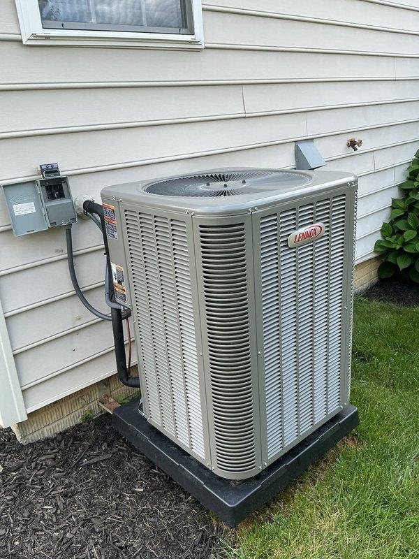 Responded to service call regarding loud boom noise coming from outdoor condenser unit when A/C system starts up, following recent installation. Performed visual inspection of Lennox ML14KC1-036-230A0 condenser unit and electrical connections. Documented unit specifications including R-454B refrigerant charge of 7 lbs 6 oz, electrical ratings, and proper mounting on concrete pad. Verified disconnect box installation and conduit routing from house to unit. Captured photographic documentation of equipment nameplate data and overall installation condition for warranty evaluation purposes.