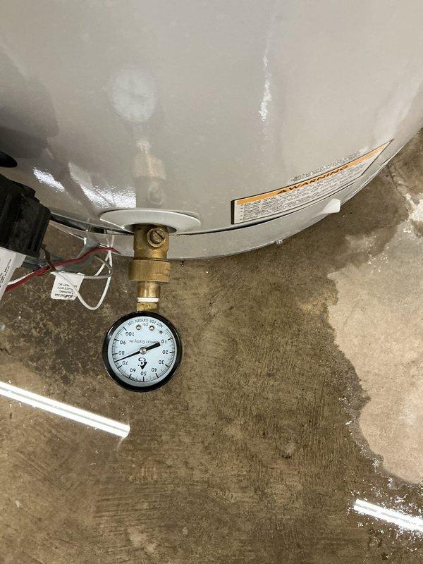 Responded to service call for water heater with no hot water production and pilot light failure. Upon arrival, inspected tanked water heater unit and confirmed pilot light would not ignite. Performed diagnostic assessment of gas control valve, thermocouple, and pilot assembly. Examined pressure gauge readings and verified gas supply to unit. Investigated pilot orifice for blockages and tested thermopile output. Additionally, inspected water fountain per customer request for suspected clog condition. Documented equipment conditions with photographs showing water heater valve assembly, pressure gauge, and internal mechanical components.