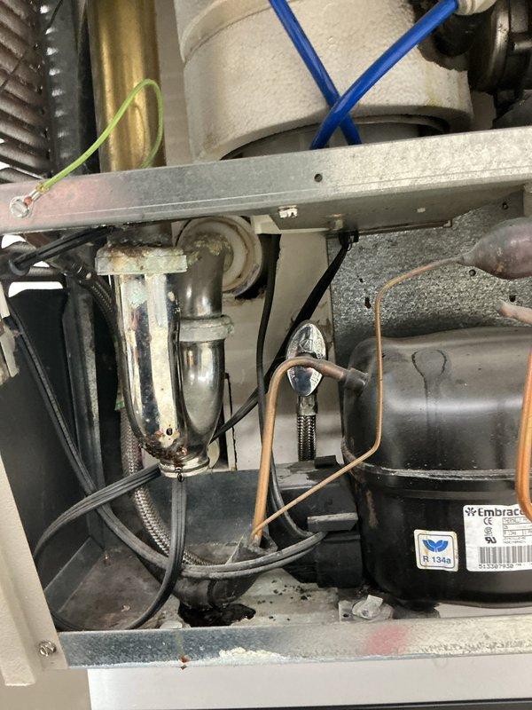 Responded to service call for water heater with no hot water production and pilot light failure. Upon arrival, inspected tanked water heater unit and confirmed pilot light would not ignite. Performed diagnostic assessment of gas control valve, thermocouple, and pilot assembly. Examined pressure gauge readings and verified gas supply to unit. Investigated pilot orifice for blockages and tested thermopile output. Additionally, inspected water fountain per customer request for suspected clog condition. Documented equipment conditions with photographs showing water heater valve assembly, pressure gauge, and internal mechanical components.