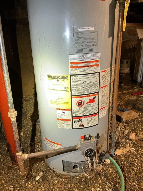 Conducted on-site assessment of existing gas water heater installation in basement of 1920s-era residential property to provide replacement estimate for 40-gallon gas unit. Inspected current water heater configuration, including gas supply connections, copper water piping, venting system, and existing drain pan setup. Documented existing plumbing infrastructure, noting basement access conditions, clearance requirements, and connection points for new installation. Evaluated gas line adequacy, flue venting pathway, and code compliance considerations for vintage home construction. Photographed current water heater condition, plumbing connections, pressure relief valve discharge piping, and surrounding utility space to support accurate material and labor estimate preparation.