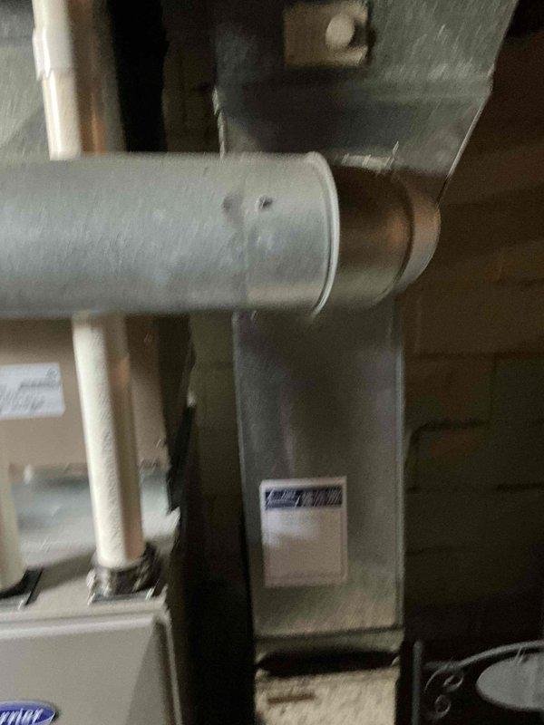 Conducted air conditioning replacement estimate at residential property, meeting with occupant to assess existing HVAC system. Documented current equipment configuration including furnace/air handler unit, galvanized ductwork with horizontal runs and elbow connections, and associated copper refrigerant lines in basement mechanical room. Photographed installation to provide comprehensive assessment for replacement system recommendations.