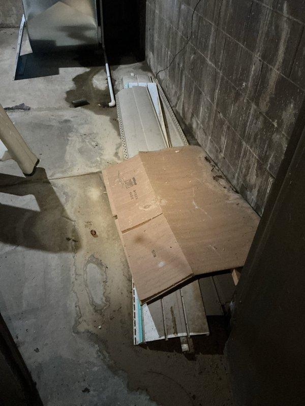 Responded to toilet leak at base with water accumulating on basement floor. Upon arrival, confirmed active water leakage despite shut-off valve being closed, indicating supply line or valve failure rather than toilet seal issue. Documented extensive water damage on concrete basement floor with visible pooling and moisture stains throughout the area. Assessed mechanical room conditions and surrounding equipment exposure to water. Photographed affected areas showing water accumulation near water heater and other utilities. Shut off main water supply to prevent further flooding and recommended immediate replacement of faulty shut-off valve and inspection of toilet mounting flange and wax ring seal.