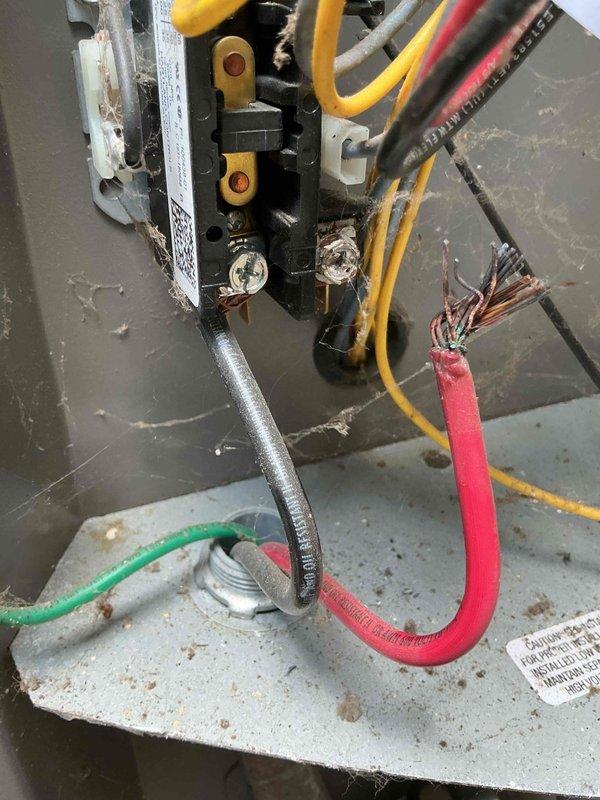 Completed MVP cooling maintenance visit on 6-year-old system located outside basement door. Upon inspection, discovered damaged wiring at contactor with exposed and frayed copper conductors on red power wire, presenting potential safety hazard and operational risk. Documented equipment condition with photos showing outdoor condenser unit on concrete pad and electrical connection assembly with compromised wiring requiring future repair or replacement to ensure safe system operation.
