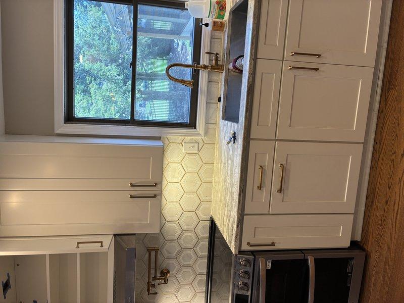 Responded to electrical service call regarding garbage disposal on shared circuit with under-cabinet lighting causing operational issues, and Ring doorbell functioning remotely but not chiming inside the house. Inspected kitchen electrical panel and under-sink disposal installation. Identified garbage disposal and under-cabinet light on same 15-amp circuit causing overload condition when both appliances operated simultaneously. Verified disposal unit properly wired with dedicated outlet under sink. Assessed doorbell transformer and chime unit wiring. Documented existing electrical configuration with photos showing disposal installation, kitchen layout, and circuit connections for customer records and future reference.
