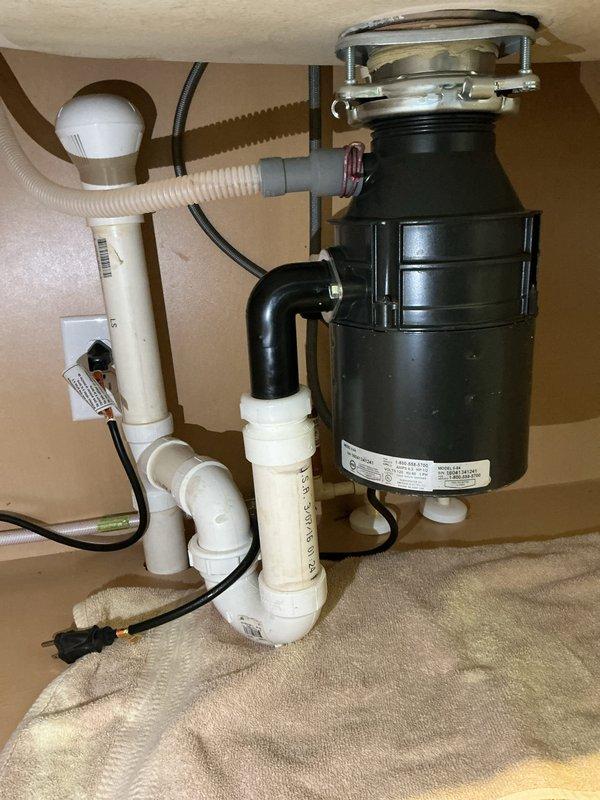Responded to service call for leaking garbage disposal unit. Upon inspection, found active leak at disposal mounting assembly beneath kitchen sink. Per customer request, bypassed and removed the garbage disposal system, then reconfigured drain plumbing with direct connection from sink basin to existing P-trap assembly using appropriate PVC fittings. Tested drain flow and verified no leaks present in modified configuration. System restored to full operation without garbage disposal unit.