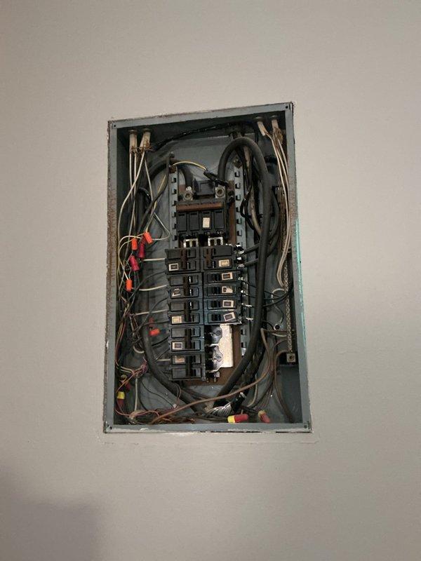 Performed electrical inspection of recently installed main circuit breaker panel and evaluated electric baseboard heater issue in bedroom. Inspected panel wiring configuration, circuit breaker arrangement, and overall installation quality, documenting panel condition with photographs showing dual-column breaker layout and wire routing. Assessed malfunctioning electric baseboard radiator that would not shut off and provided recommendations regarding removal versus leaving in place, as unit was believed to be out of service but remained energized.