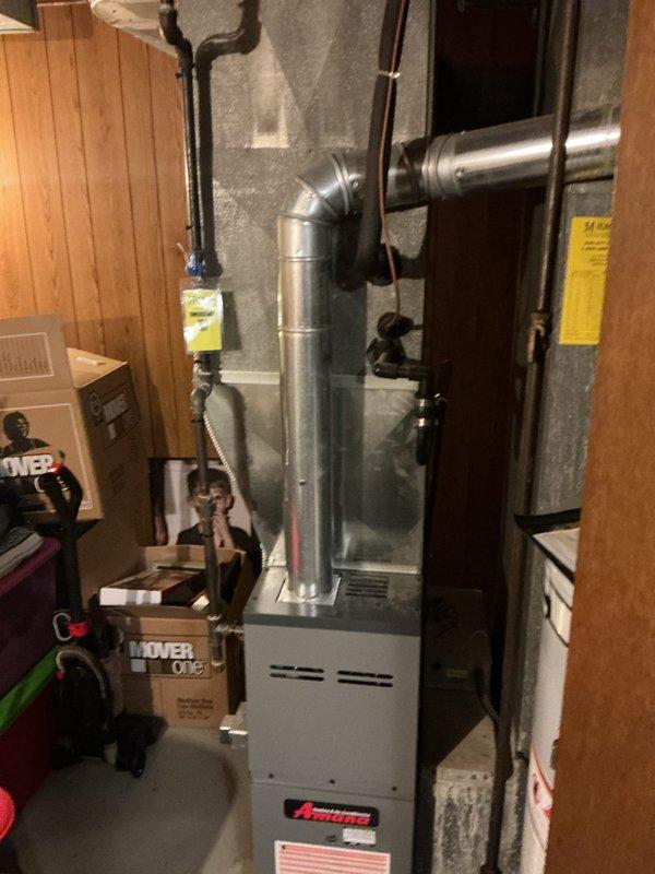 Completed installation of dual A/C units with corresponding evaporator coils in a residential property. Mounted two condenser units on exterior foundation pad against brick wall with proper spacing and leveling, installed refrigerant line sets and electrical conduit secured to building exterior, and connected both systems to existing Amana furnace infrastructure in basement. All refrigerant lines were properly insulated, electrical connections were made to code, condensate drains were installed, and both systems were charged, tested, and verified for proper operation.