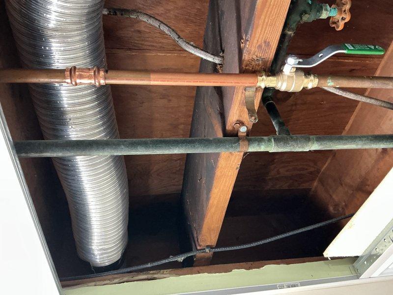 Responded to a broken copper pipe repair in an accessible drop ceiling space. Removed and replaced a corroded section of copper piping that showed significant oxidation and verdigris buildup around the valve fitting area. The deteriorated pipe segment was cut out and a new copper pipe section was installed using proper compression fittings, ensuring secure connections and proper alignment with existing plumbing infrastructure. All work was completed within the wooden joist framework alongside existing HVAC ductwork, with minimal disruption to surrounding systems.
