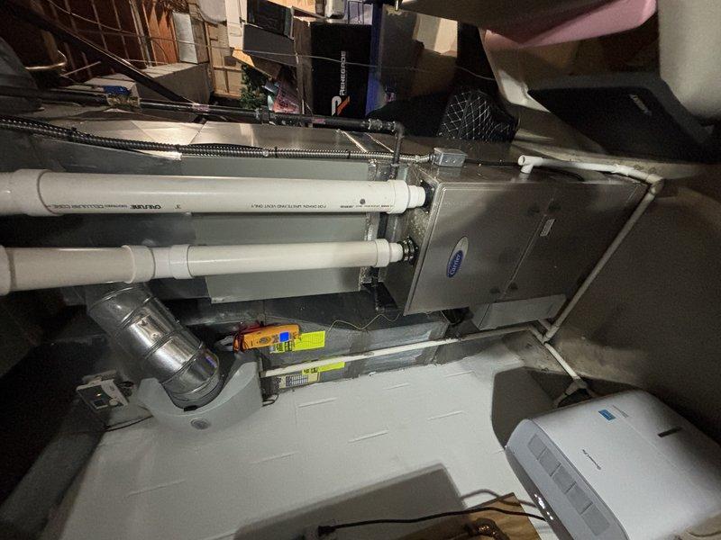 Completed recurring maintenance visit on 16-year-old cooling system. Performed standard inspection of HVAC unit, ductwork connections, and associated components in mechanical room. During inspection, identified damaged P-trap with visible crack on condensate drain line requiring attention. Documented system condition and plumbing concerns with photographs for service records.