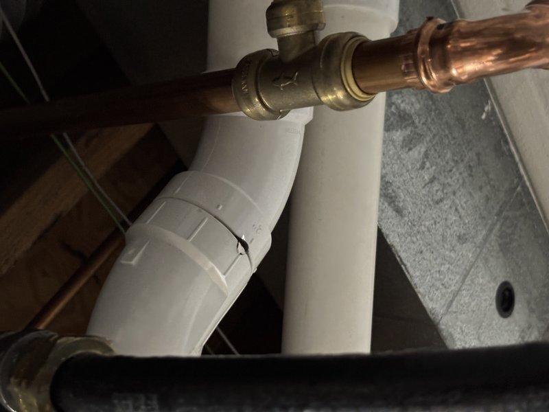 Completed recurring maintenance visit on 16-year-old cooling system. Performed standard inspection of HVAC unit, ductwork connections, and associated components in mechanical room. During inspection, identified damaged P-trap with visible crack on condensate drain line requiring attention. Documented system condition and plumbing concerns with photographs for service records.