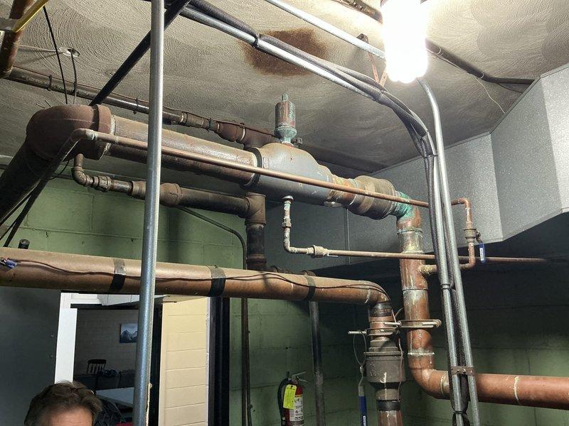 Conducted comprehensive site assessment of existing commercial boiler system and associated hydronic piping infrastructure to provide replacement estimate. Documented current mechanical room configuration, including extensive network of aged copper and steel distribution piping showing significant oxidation and patina development throughout the heating system. Evaluated overhead piping layout, support structures, and existing valve arrangements to determine scope of replacement work and integration requirements for new boiler installation.