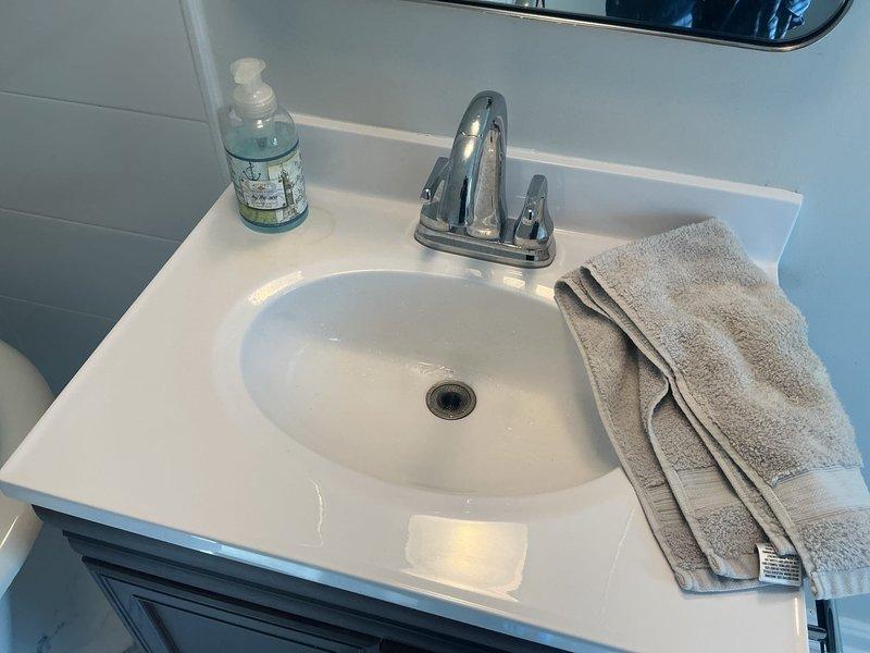 Responded to complaint of rusty hot water at third floor bathroom sink. Upon arrival, performed diagnostic inspection of the affected fixture and water supply system. Tested hot water quality and observed discoloration consistent with sediment or corrosion in the water lines. Inspected the chrome two-handle centerset faucet and confirmed proper operation of both hot and cold water valves. Examined the supply lines and connections beneath the vanity for signs of deterioration or buildup. Documented findings with photographic evidence showing water quality issues in the basin. Recommended further evaluation of the water heater and hot water distribution system to identify the source of sediment causing the rusty appearance in the water supply.