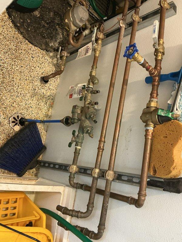 Completed backflow prevention device inspection and testing at commercial kitchen facility. Tested backflow assembly with brass fittings and shut-off valves, verifying proper operation of check valves and relief valve per local plumbing code requirements. All components passed inspection with acceptable pressure differential readings. Documented existing copper pipe configuration and valve conditions with photographic evidence for compliance records.