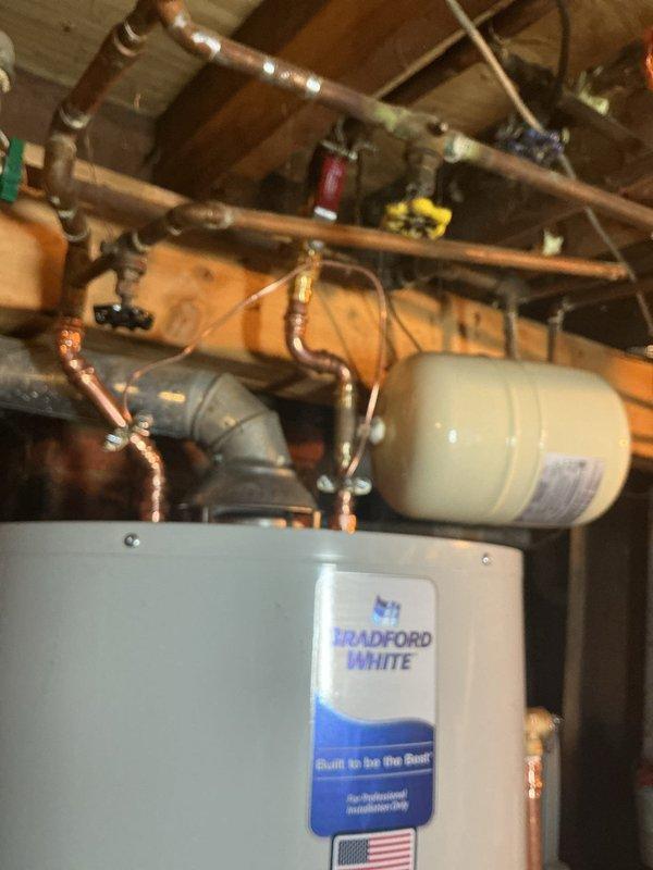 Successfully installed a new 40-gallon Bradford White water heater with 6-year manufacturer warranty, including a new ball valve and expansion tank. All copper piping connections were completed, and the unit was properly mounted and secured in the basement mechanical room. The installation meets current safety standards with appropriate warning labels visible and all components functioning as specified.