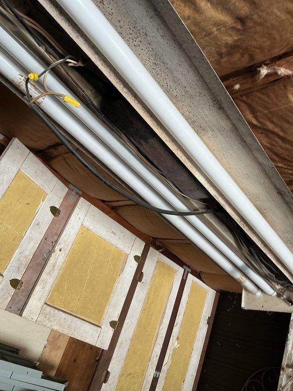 Corrected code violations in detached structure subpanel by separating improperly bonded grounds and neutrals onto individual bus bars per NEC requirements. Removed and replaced improper PVC feeder conduit on exterior, installed expansion coupling on riser, and terminated conduit into subpanel using appropriate weatherproof fittings. Installed ground rod system to properly ground detached structure and sealed unused panel knockouts to maintain enclosure integrity.