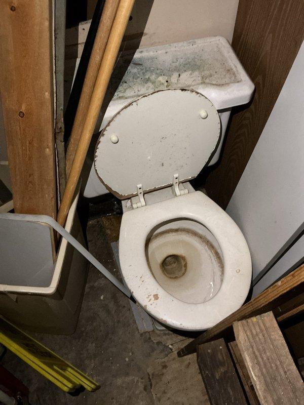 Responded to service call for non-functional second bathroom toilet. Upon arrival, inspected toilet unit located in unfinished utility space showing significant age-related deterioration including rust staining around rim, interior bowl discoloration, and exterior grime accumulation. Diagnosed operational issue and performed necessary repairs to restore toilet to working condition. Completed work prior to requested timeframe to accommodate occupant schedule.