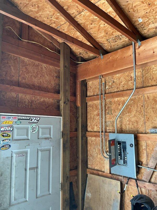 Installed electrical infrastructure in detached shed to accommodate 220V circuits for welder operation. Mounted and wired electrical panel with appropriate circuit breakers, ran metallic conduit from panel along wall and ceiling joists, and installed 220V receptacle outlet in floor-mounted junction box. All work completed to code specifications for safe operation of high-amperage welding equipment.