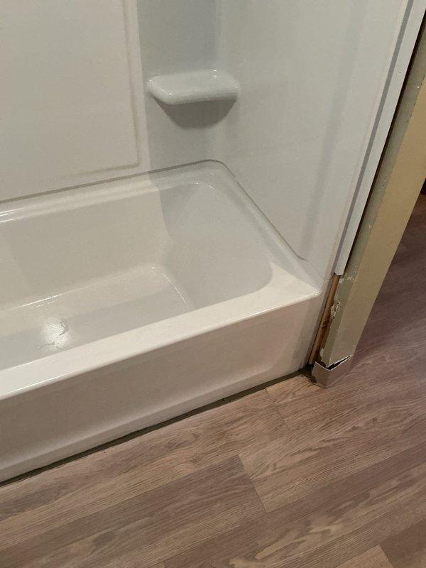 Installed a 30x60 white fiberglass bathtub and shower surround unit with integrated soap dishes and built-in threshold. Accessed and connected drain lines by opening the ceiling below the installation area, with customer acknowledgment that drywall repair is not included in scope of work. Completed installation with proper trim work and sealing after parts arrived and were available for use.