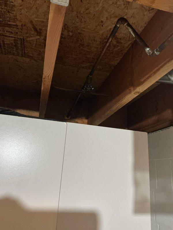 Responded to service call for two leaking outdoor spigots on 30-year-old residential property. Upon inspection, identified active leaks at both exterior hose bibs. Accessed interior plumbing connections through utility closet and crawl space area to assess supply lines and shut-off valves. Documented existing conditions showing black supply piping and mounting configuration in confined mechanical space. Completed diagnostic evaluation of both spigot assemblies and associated plumbing infrastructure to determine repair requirements.
