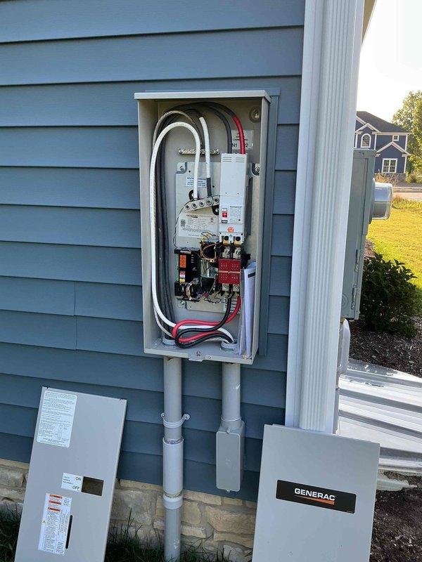Performed on-site evaluation and provided estimate for residential Generac generator installation. Assessed existing electrical infrastructure including main service panel, transfer switch location, and required conduit routing on exterior wall. Documented current electrical panel configuration with circuit breakers and main service connections, verified proper mounting locations for generator transfer switch and associated equipment on home's exterior siding, and photographed customer connection terminals and high-gauge power cable routing requirements for the proposed automatic transfer switch installation.