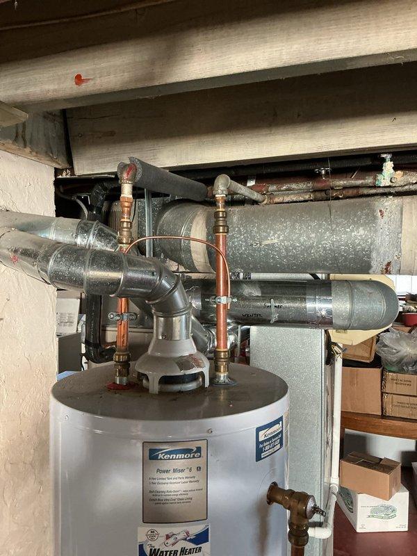Responded to service call for 18-year-old Kenmore Power Miser water heater with pilot light failure. Upon arrival, pilot light would not remain lit and only flashed intermittently, indicating thermocouple or gas valve issues typical of aged units. Inspected burner assembly, thermocouple positioning, and gas control valve on this residential basement installation. Given the advanced age of the unit and the nature of the pilot failure, recommended replacement rather than repair due to diminished reliability and efficiency of components approaching end of service life. Documented existing installation configuration including copper supply lines, compression fittings, shut-off valves, and venting system for future reference.