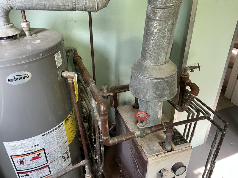 Performed estimate on 42+ year old Hydro Therm gas-fired boiler serving baseboard heating system. Unit exhibits extensive deterioration including rusted-out components, heavily corroded internal mechanisms, and degraded manufacturer plates. Boiler shows significant age-related wear with gummed-up controls and compromised structural integrity. Documented equipment condition with photographs showing weathered housing, oxidized copper piping, deteriorated flue connections, and overall system decline. Provided quote for boiler replacement due to unit being beyond serviceable life expectancy.