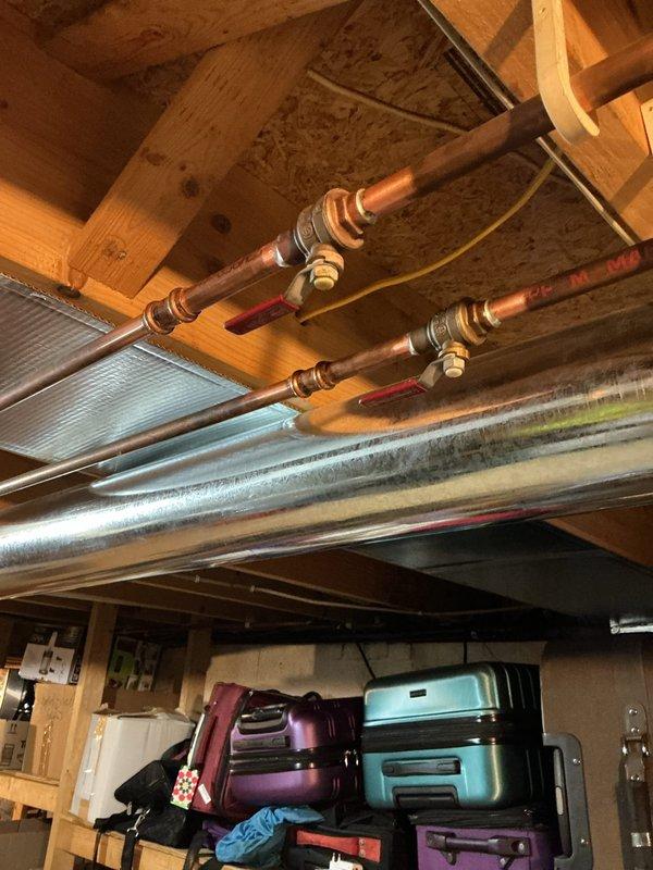 Responded to service call for corroded plumbing in basement. Upon inspection, found severely deteriorated copper pipes with extensive mineral deposits and white crystalline buildup around connection points, indicating advanced corrosion and imminent failure risk. Documented existing rusted pipe conditions throughout basement area, including oxidized copper lines with compromised fittings near HVAC ductwork. Recommended complete pipe replacement to prevent potential burst and water damage.