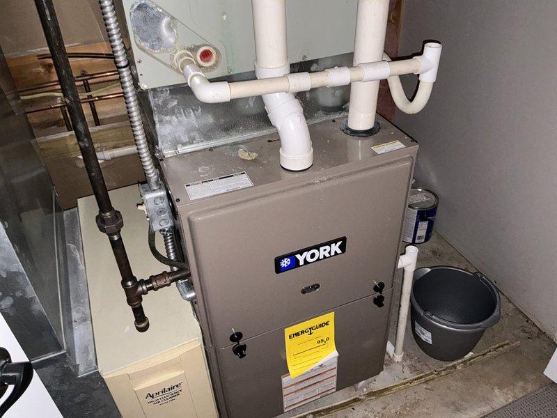 Conducted comprehensive HVAC system evaluation for replacement estimate on 16-year-old York furnace installation. Assessed existing equipment configuration including furnace unit, PVC drainage and ventilation systems, ductwork connections, electrical components, and condensate management setup in basement utility space. Documented current system condition through photographic records and provided customer with replacement options for aging heating system.