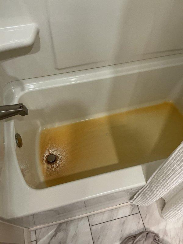 Responded to a hall bathroom drain blockage affecting a separate branch line in the drainage system. Upon arrival, found several inches of standing water in the bathtub and discolored water present in fixtures due to drain backup. The back pressure from the blocked line had compromised the toilet's wax seal, causing water to leak onto the bathroom floor with potential seepage into the crawl space below. 

Evacuated standing water from both the bathtub and toilet bowl to prepare for drain clearing operations. Removed and set aside the toilet to access the drain line directly. Deployed mechanical snake through the exposed drain opening to locate and clear the obstruction in the branch line. Successfully broke through the blockage and restored proper drainage flow throughout the affected branch line. 

Verified clearance by running water through the system and confirming adequate flow with no backup. Reinstalled the toilet with a new wax ring seal from truck stock to ensure proper waterti