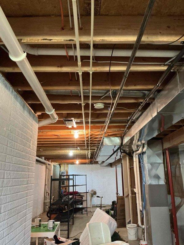 Performed electrical estimate for generator installation in unfinished basement utility space. Assessed existing electrical infrastructure including 200-amp Eaton BMH125K circuit breaker panel with proper UL certification and busbar configuration. Documented site conditions including exposed ceiling joists, existing plumbing and HVAC systems, concrete block walls, and available floor space for equipment placement. Evaluated electrical service capacity and panel accessibility for generator transfer switch integration. Photographed electrical panel specifications, existing conduit routing, and workspace layout to prepare comprehensive installation estimate.