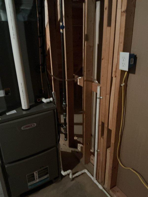 Replaced an 80-gallon AO Smith electric water heater experiencing severe corrosion with a new Navien NPE-240A2 tankless water heater. Connected gas supply to existing 1-inch main trunk line and mounted unit in utility area. Core drilled through brick exterior wall at front of house for proper venting and exhaust installation. Installed condensate pump with discharge line routed to furnace drain location. Coordinated electrical conversion from 240V to 110V service. All copper supply lines connected, system tested and operational.