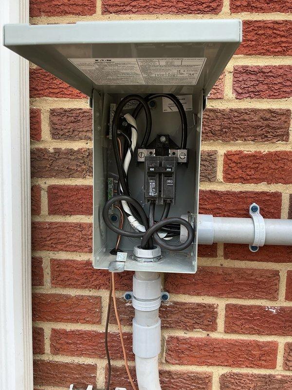 Replaced existing 100 amp electrical panel with new unit and installed exterior 100 amp disconnect on brick wall. Extended waterline grounding conductor to new disconnect location to ensure proper system bonding. Verified existing grounding infrastructure including visible ground rods and hot water tank bonding for code compliance. Installed white PVC conduit from exterior disconnect down brick wall for weather protection. Organized and terminated all branch circuit wiring within new interior panel, arranging circuit breakers in dual columns. Routed service conductors through gray conduit from panel to exterior disconnect. Single technician completed full installation over one work day after parts arrived at shop.