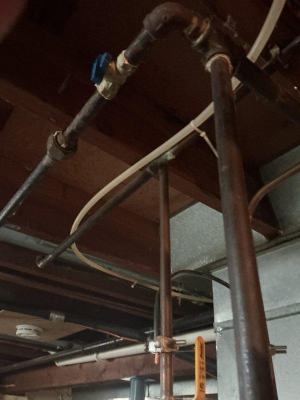 Provided estimate for conversion from existing 40-gallon gas water heater to 10-gallon electric unit in basement utility area of 1958-built residence. Assessed current installation including gas supply line, venting system, and existing plumbing connections with copper piping. Estimate includes disconnection and removal of gas water heater, capping of gas line per code requirements, installation of appropriate electrical circuit and wiring for electric unit, reconfiguration of water supply and discharge piping to accommodate smaller capacity tank, and proper mounting and connection of new electric water heater with required temperature and pressure relief valve and discharge piping.