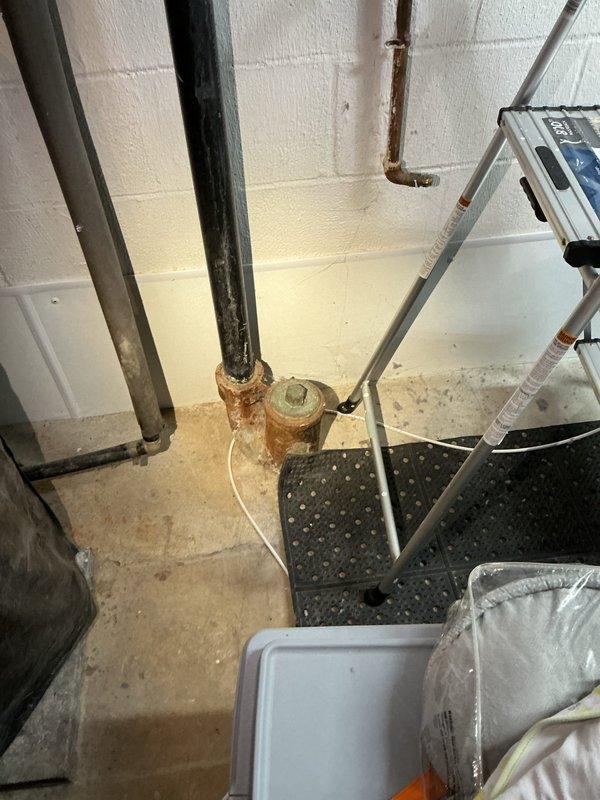 Responded to basement drain backup from clothes washer. Upon inspection, discovered heavily corroded cast iron drain fitting and pipe assembly with significant rust deterioration and internal buildup causing drainage obstruction. Cleared blockage from drain line, removed debris and sediment accumulation from fitting interior. Tested drain flow and verified proper drainage from washer discharge. Documented existing corrosion on pipe assembly and recommended future replacement of deteriorated fittings to prevent recurrence.
