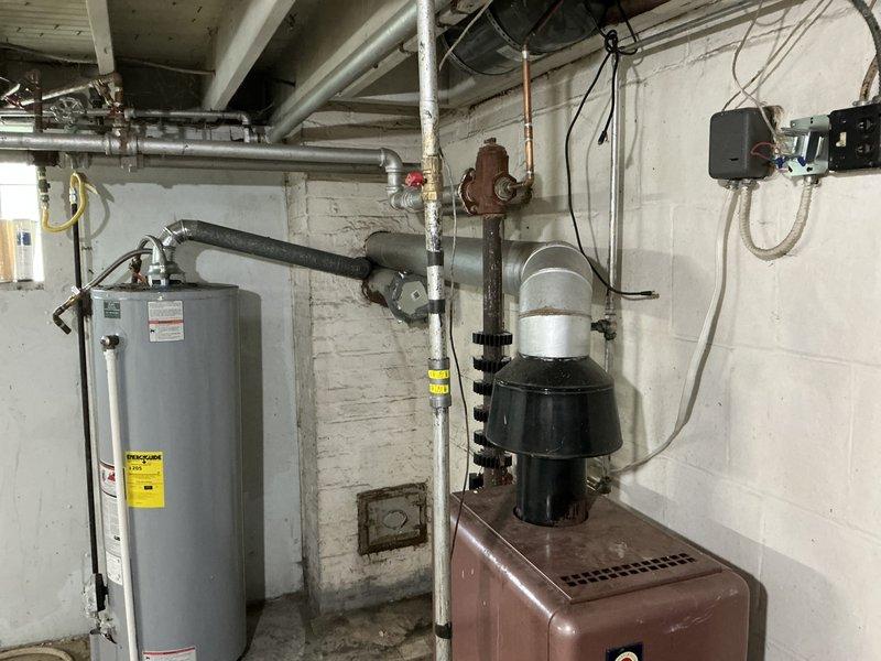 Conducted on-site assessment for complete residential boiler replacement. Existing heating system is approximately 50 years old and has reached end of serviceable life. Documented current basement installation including aging boiler unit with associated piping infrastructure, water heater, and electrical components. Evaluated existing mechanical room layout, pipe routing, and clearance requirements for new equipment installation. Assessed attic space and heating distribution system to determine compatibility with proposed replacement boiler. Provided comprehensive quote for new whole-house boiler system installation.