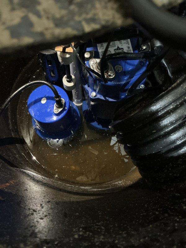 Replaced two 10-year-old sump pumps in the basement with new Level 1 all-in-one battery backup systems. The first unit was located in the utility room in the middle of the basement, and the second was positioned in the northeast corner of the basement. Both existing pumps had bolted crock lids which were removed during the replacement process. Successfully installed both new battery backup sump pump systems, ensuring proper operation and backup power capability for continued basement protection against water intrusion.