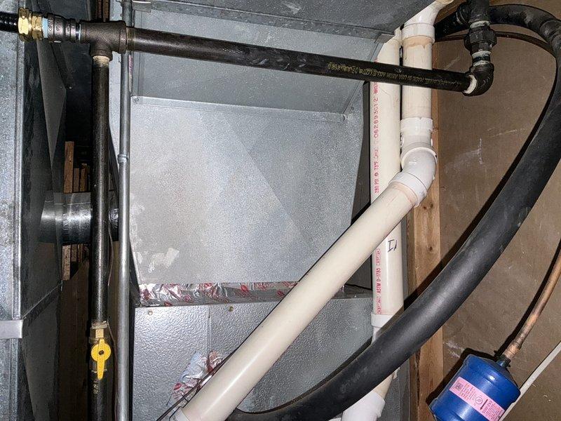 Completed furnace replacement estimate for an 18-year-old heating system with no cooling capability. Documented existing Duane-branded furnace unit with associated ductwork, PVC venting, gas piping with yellow shutoff valve, and black flexible ducting connections. Assessed mechanical room layout including all plumbing, ventilation components, and structural considerations for replacement equipment specifications.