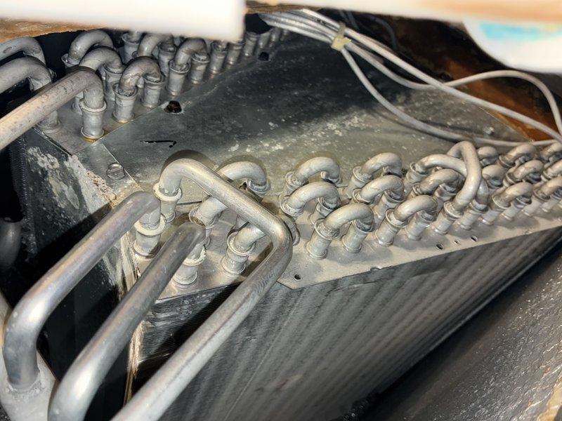 Completed comprehensive air conditioning tune-up service including visual inspection of evaporator coil assembly and heat exchanger components. System components showed normal operational wear with some dust accumulation; all major elements including refrigerant lines, coil fins, and electrical connections were assessed and found to be functioning within acceptable parameters.