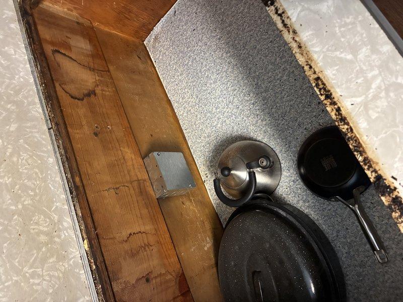 Replaced outdated cloth-wired stovetop circuit with new four-wire configuration (two hots, neutral, and ground) to meet current code requirements for new appliance installation. Ran new circuit from main electrical panel through crawl space to countertop location, installed junction box in cabinet with breaker lock at panel, and properly capped existing circuit in approved junction box. Repaired open splice above panel to eliminate safety hazard.