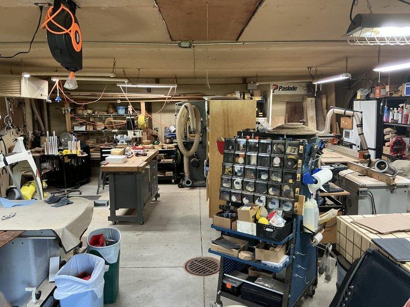Conducted site assessment for mini split installation in well-insulated garage woodworking shop. Evaluated existing electrical infrastructure including Square D load center with available breaker capacity and confirmed adequate 8/3 wiring at 130 amp service for system requirements. Documented workspace layout, ceiling structure with exposed concrete and fluorescent lighting, and optimal placement considerations for indoor and outdoor unit installation to ensure efficient climate control for the active workshop environment.