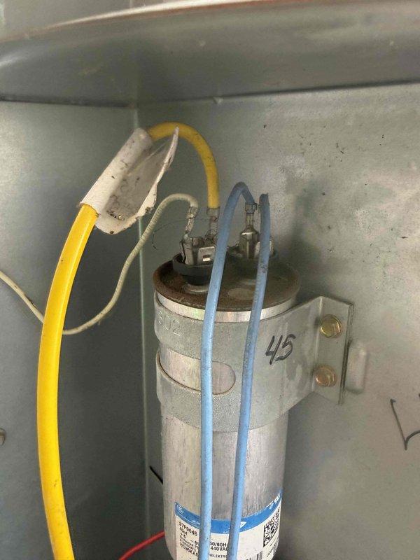 Responded to no cooling complaint on aging residential air conditioning system. Upon inspection, confirmed compressor failure with unit unable to produce cool air. Accessed outdoor condensing unit and indoor furnace components to diagnose issue. Tested capacitor (marked as 45 MFD) and verified electrical connections to compressor. System age estimated at 10+ years or older, indicating equipment is near or beyond expected service life. Documented equipment condition with photos showing furnace interior, blower assembly, and capacitor installation. Advised customer that compressor replacement may not be cost-effective given system age and recommended evaluation for complete system replacement.
