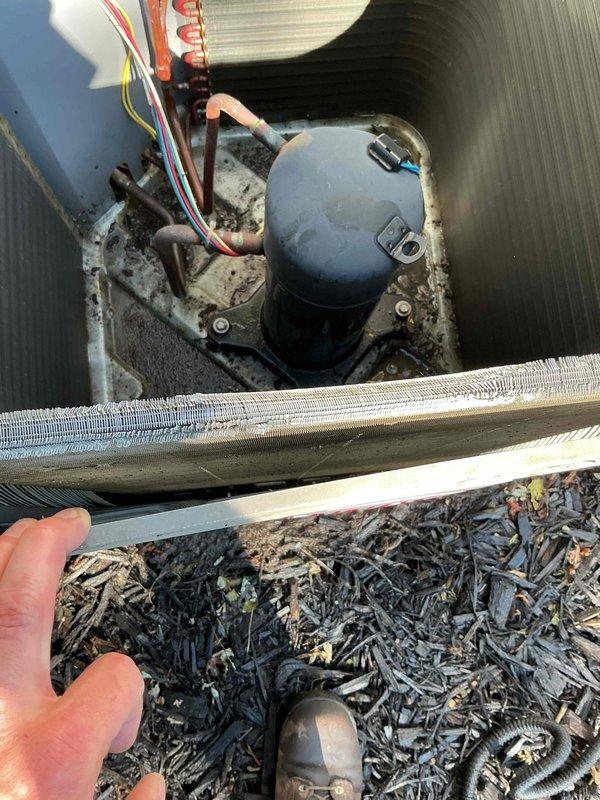 Responded to service call for water leak on 10-year-old air conditioning system. Upon arrival, performed visual inspection of outdoor condenser unit, which showed significant exterior corrosion and deterioration of cabinet panels. Noted heavy accumulation of dirt, debris, and organic matter around unit perimeter and against adjacent fence line.

Opened access panel to inspect interior components and evaporator coil assembly. Found compressor and internal components operational but surrounded by accumulated debris on base pan. Inspected evaporator coil and identified restricted airflow due to dirt buildup on aluminum fins. Examined condensate drain system and located clog in drain line causing water backup and overflow.

Cleared condensate drain line obstruction using appropriate tools and verified proper drainage flow. Cleaned debris from base pan and surrounding areas. Tested system operation to confirm water now draining properly through condensate line without leakage. Documented eq