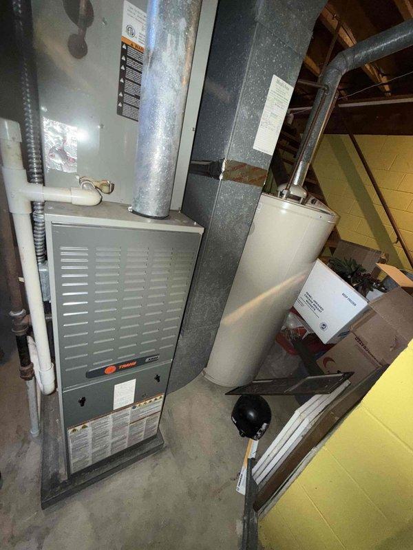 Completed standard AC tune-up on residential split system located in basement mechanical room. Inspected Trane furnace and associated ductwork, noting moderate dust accumulation on evaporator coil fins. Performed visual inspection of system components, verified proper operation, and documented equipment condition through photographs. Unit operational upon completion of service.