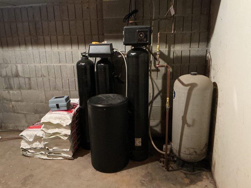 Completed comprehensive 26-point plumbing inspection on 47-year-old residential property equipped with private well water system and multi-tank water treatment setup installed in January 2020. Inspected gas-fired water heater located in basement utility area, verifying proper copper piping connections, temperature/pressure relief valve operation, and venting system integrity. Evaluated complete water treatment system consisting of multiple filtration tanks with digital control panel, pressure tank, and associated plumbing connections to ensure proper operation and settings since original installation. Assessed all visible copper supply lines, drainage systems, fixtures, and plumbing components throughout accessible areas of the home. Verified water pressure levels, checked for signs of leaks or corrosion on exposed piping, and confirmed proper function of well system components. Documented current condition of all major plumbing infrastructure with photographic evidence for maintenance