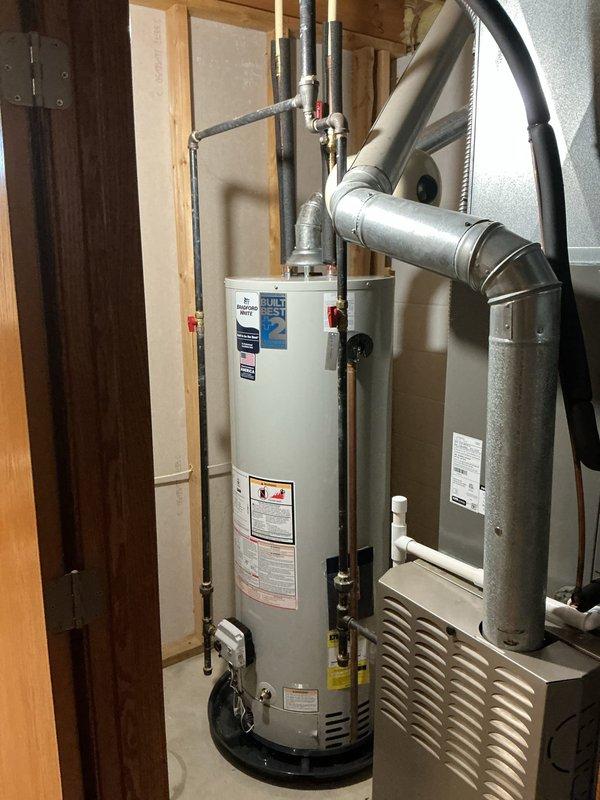 Removed and replaced existing water heater with new Bradford White 40-gallon tall model in residential utility room. Installation included new expansion tank and water shut-off valve to meet current plumbing code requirements. Connected copper supply lines and piping to unit, verified all connections for proper seal and operation. Unit is covered under 8-year manufacturer warranty with extended 2-year warranty for total 10-year coverage. Tested system for proper heating function, checked temperature and pressure relief valve operation, and confirmed no leaks at all connection points. Water heater installed adjacent to existing HVAC furnace unit in mechanical closet with adequate clearance for maintenance access.
