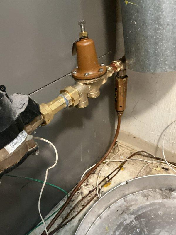 Replaced existing water heater with new 40-gallon tall Bradford White tank water heater including 8-year tank warranty. Installation included new water shut-off valve and thermal expansion tank to protect against pressure buildup in the system. Installed pressure reducing valve near the water meter to regulate incoming water pressure. Replaced second shut-off valve and installed tee connection for trap primer. All copper piping connections completed with brass fittings to ensure proper water flow and system integrity. Parts were coordinated for delivery and staged prior to installation. Required two-person crew for safe removal of old water heater unit.
