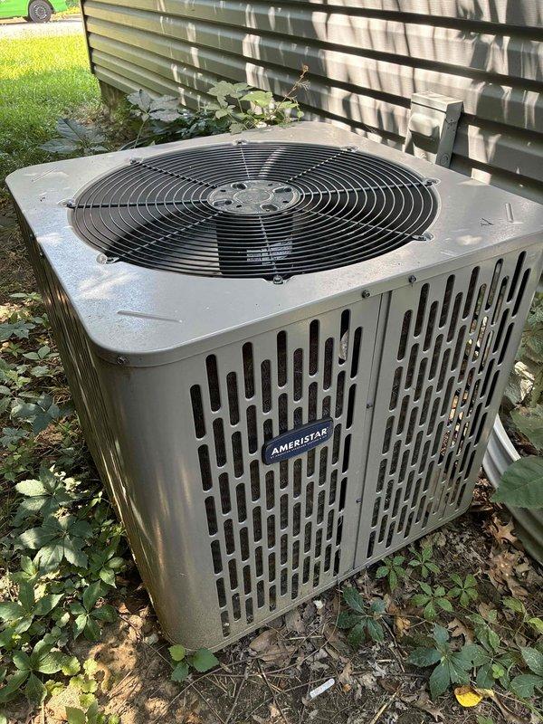 Performed routine tune-up maintenance on outdoor Ameristar condenser unit approximately 6 years old. Completed standard inspection procedures, verified operational temperatures with digital thermometer showing 51.2°F at measurement point, and documented equipment condition through photographs. Unit found in satisfactory operating condition with normal airflow through cabinet vents and fan assembly functioning properly.